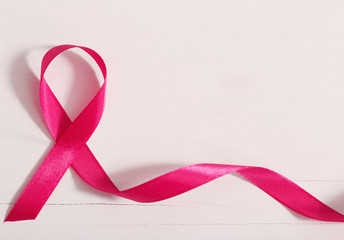 healthcare and medicine concept. pink breast cancer awareness ribbon on wooden white background