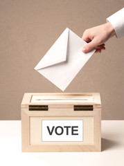 Close up of male hand putting vote into a ballot box