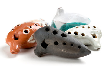 Ocarinas on white background. Orange color ocarina in glaze.