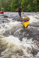 Portaging whitewater in canoes on the Noire River in Quebec, Canada.