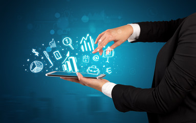 Hand holding tablet with chalk drawn symbols above