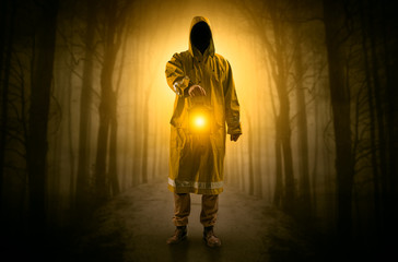 Fototapeta na wymiar Mysterious man coming from a path in the forest with glowing lantern concept