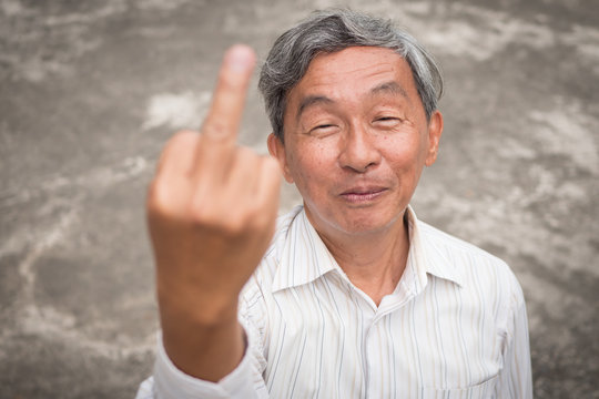 senior old man flipping middle finger, rude hand sign gesture