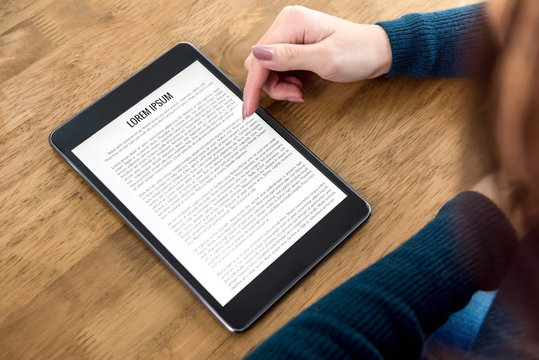 Student reading e-book reader at the table