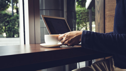 Selective focus of Side view laptop is on the work table in a conner office with morning light.