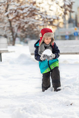 Fototapeta na wymiar Young boy playing with snow outdoors