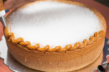 Vanilla cake withe powdered sugar and milk cream