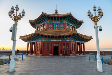 Zhanqiao pier at sunrise, Qingdao, Shandong, China. The name "Huilan Pavilion" is engraved above the entrance door.