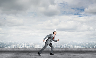 King businessman in elegant suit running on building roof and business center at background