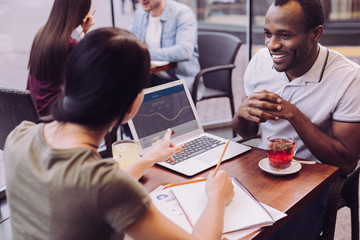 Business plan. Top view of energetic ambitious two colleagues working at cafe while woman holding pencil and pointing at the screen