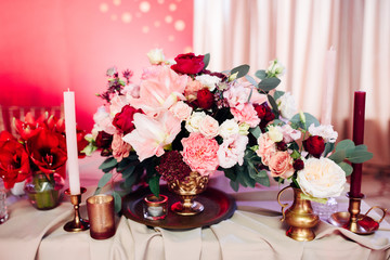 Decorated area in gold and burgundy colors with white candles and flowers