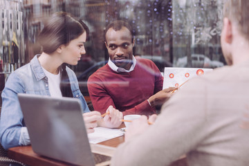Unexpected observation. Reflective musing two colleagues sitting at cafe while looking for...