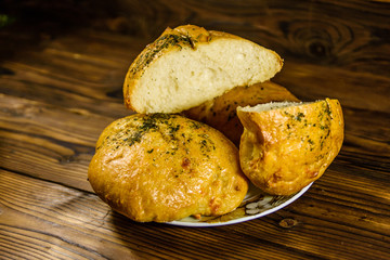 Plate with italian bun ciabatta on wooden table