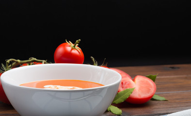 tomato soup on a wooden table front view