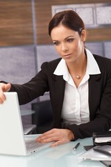 Tired businesswoman shutting down laptop