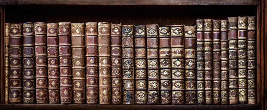 Old books on wooden shelf. Tiled Bookshelf background.