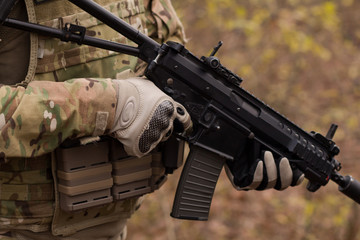 close up picture of black assault rifle in hands of nato soldier 
