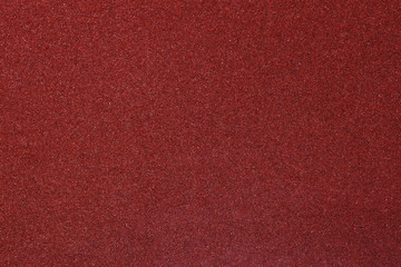 Red fine-grained sandpaper or abrasive texture abstract background  