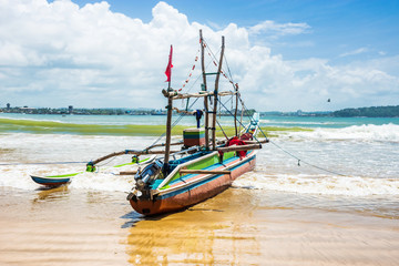 Fototapeta na wymiar Outrigger, a traditional fishing boat, on the beach near Galle, Sri Lanka.
