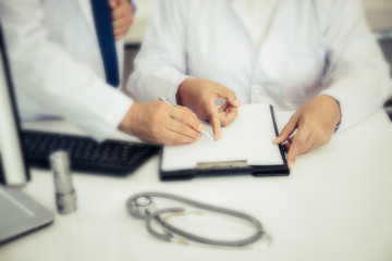 Two Doctors discussing about patient report in ward at hospital.