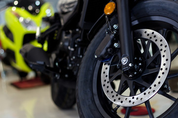Obraz premium zbliżenie opony i naczynia piec sportowego motocykla (duży rower) z nieostrym w tle i nad światłem