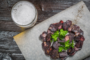 Beer from cutting horse sausage with greens on the Board for filing is covered with a sheet of parchment. The view from the top. Copy-space.