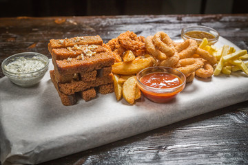 Different beer snacks with sauces on the Board for filing is covered with a sheet of parchment