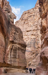 Tourists walking in Petra gorge at cold winter day