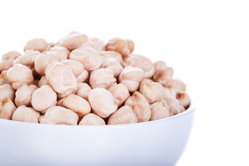 Raw dry chickpeas in bowl on white background