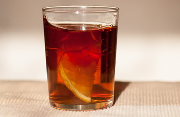 Fototapeta na wymiar Macro shot of simple glass of tea with lemon