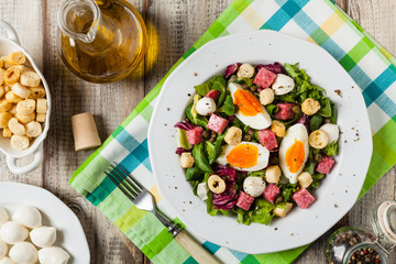 Delicious Italian salad with salami, egg, crostini and mozzarella.