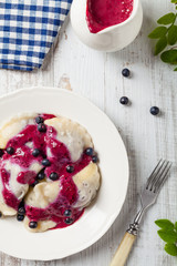 Delicious dumplings with fresh blueberries served with whipped cream and sugar or sauce.