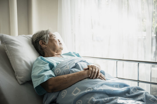 Elderly patients sitting in bed waiting for relatives to visit with loneliness.