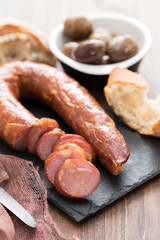 smoked sausages with bread on black ceramic board