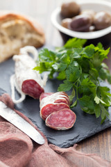 Traditional Spanish sausage Fuet on black ceramic background