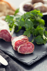 Traditional Spanish sausage Fuet on black ceramic background