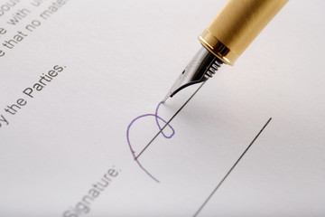 Close-up of gilded fountain pen signing contract, document.