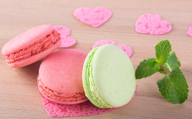 mint and pink macaron, on a wooden board, like a background to the day of Saint Valentine