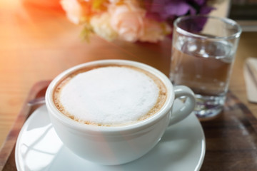 Coffee in white cup served with morning water.