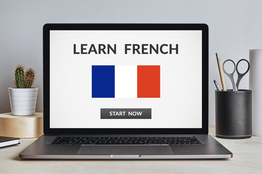 Learn French concept on laptop screen on modern desk. All screen content is designed by me. Front view.