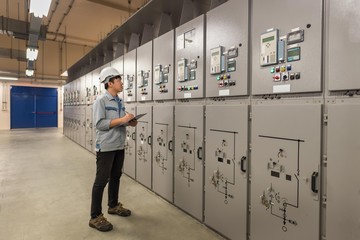 Engineer working and check status switchgear electrical energy distribution at substation room