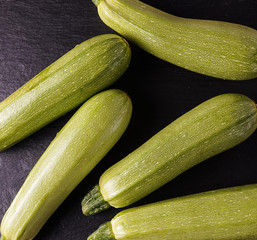 Ripe  fresh raw courgettes on black background.