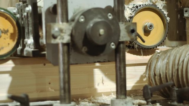 Spinning spiked wheels of block refiner machine working on wood at sawmill production, close up