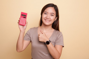 Asian woman thumbs up with calculator.