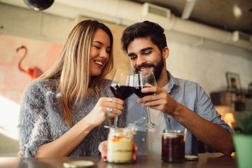 Romantic couple drinking red wine and celebrating anniversary or Valentine's day.