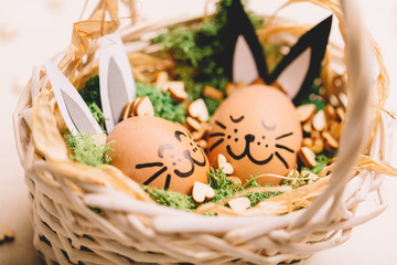 Two smiling egg-bunnies laying in the basket.