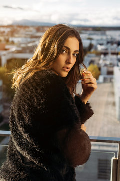 Woman in coat standing on balcony
