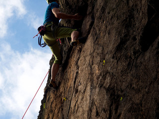 Kletterer mit grüner Hose am Felsen in schwerer Route8