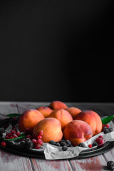 Ripe peach with berries on the table