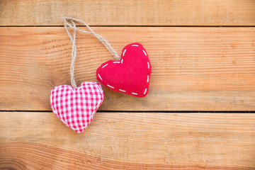 Two red fabric hearts on old wood background